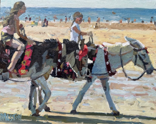 Blackpool beach donkeys having a ride along the sea