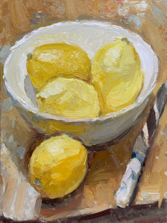 An oil painting from life of some lemons in a white bowl with a knife on the table