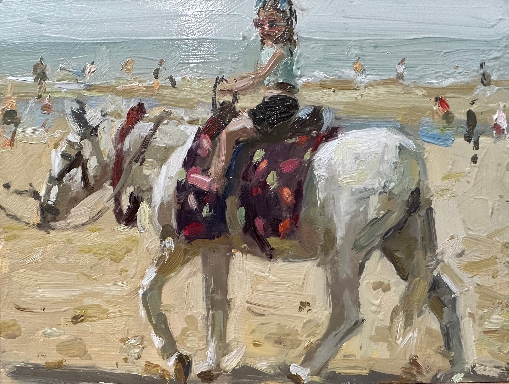 a little girl riding a beach donkey on Blackpool beach in the summer