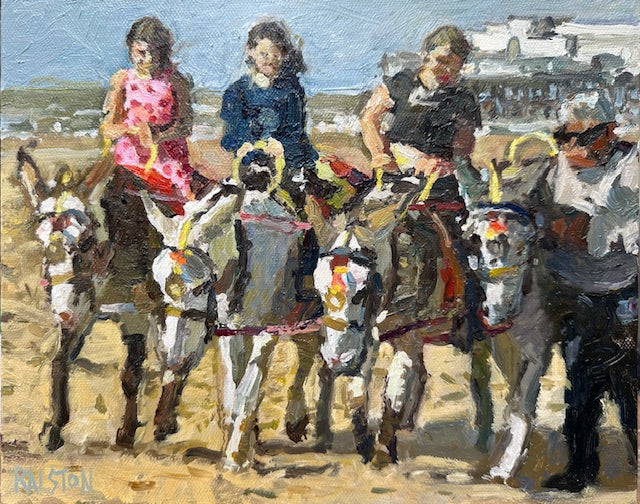 Donkey driver with four donkeys and three young girls riding