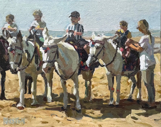 Children riding donkeys on a beach with ocean in the background
