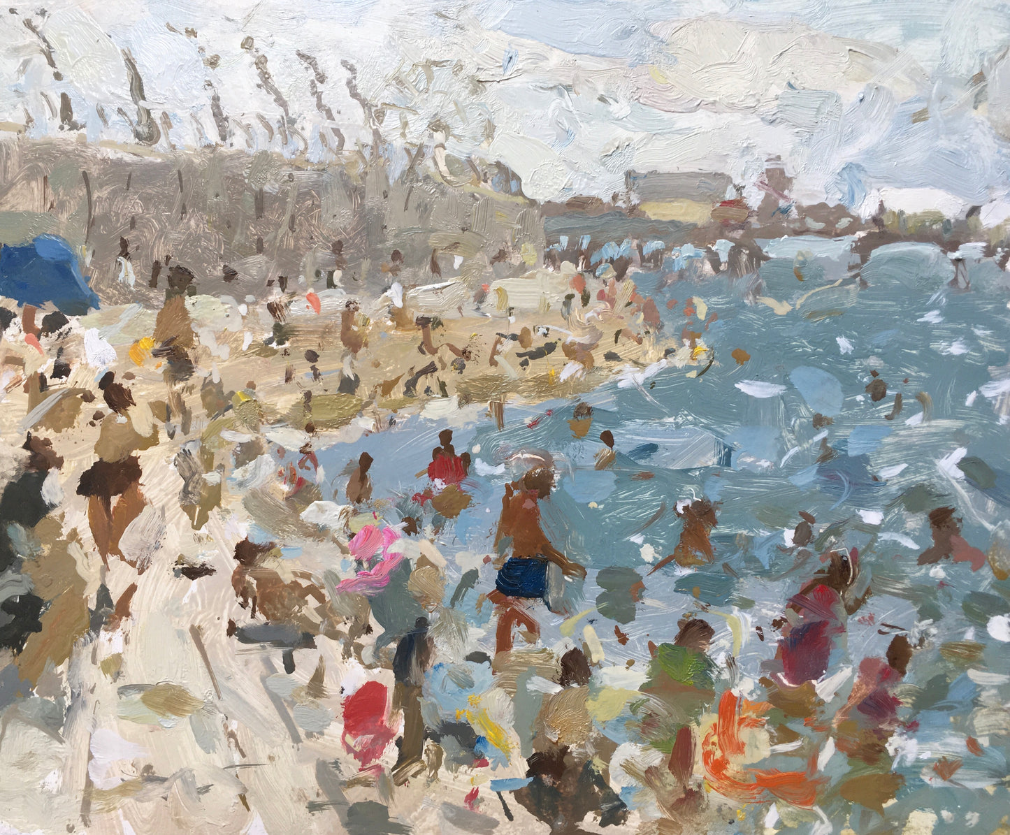 A busy beach scene with people in the sea on Blackpool promenade