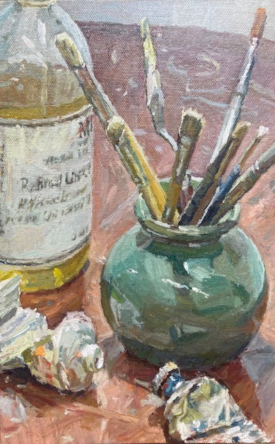 An oil painting still life depicting an artist's setup, featuring a green ceramic jar filled with paintbrushes, a bottle of linseed oil, and crumpled tubes of paint on a wooden table.