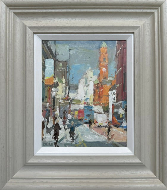 A framed impressionist painting of a city street scene with pedestrians, buildings, and a clock tower, presented in a wide light gray wooden frame with a white mat.