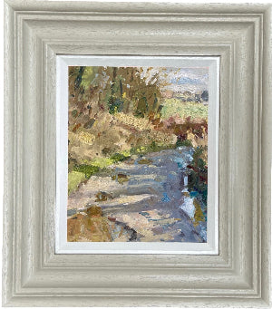 Framed landscape oil painting featuring a path with trees, puddles and fields, set within a  light gray frame and white inner slip