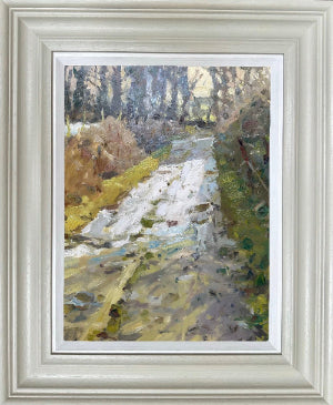 Framed impressionist landscape painting of a snowy path winding through trees, in a light gray frame with a white mat.