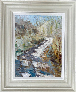 A framed impressionist landscape painting depicting a winding country path  through a grassy, rocky icy field, in a light gray frame with a white slip
