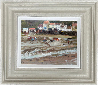 Framed coastal landscape painting of stithies harbour, featuring a beach scene with small boats, white buildings with red roofs, and textured brushstrokes in earthy tones, set within a wide light grey frame.