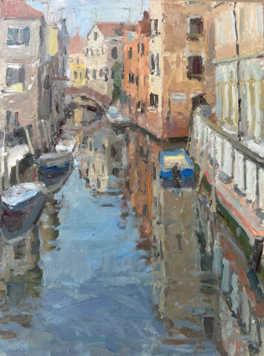 Reflections on the water in Venice with canal boats and a bridge, with light on the buildings